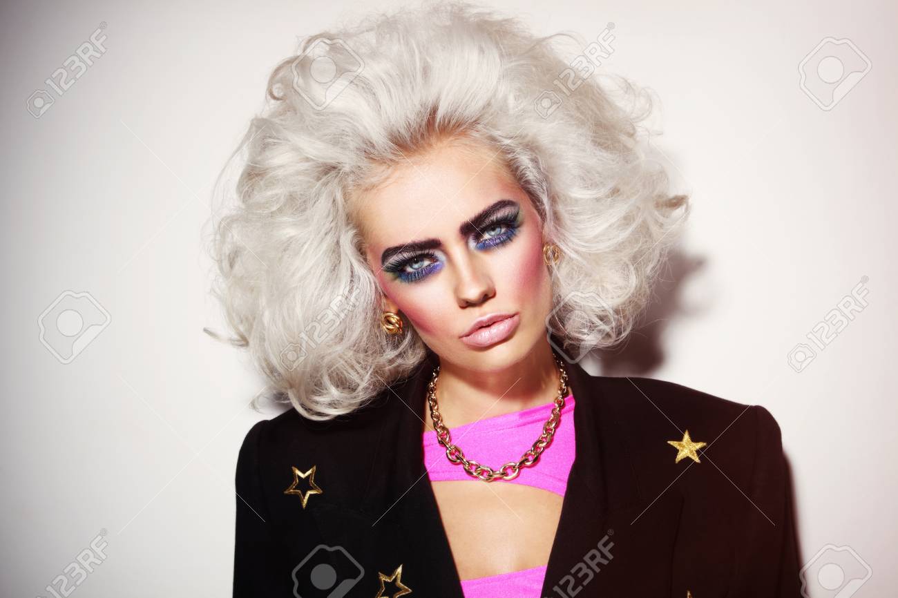 Portrait of young beautiful platinum blond woman with bold eyebrows and 80s  style makeup Stock Photo