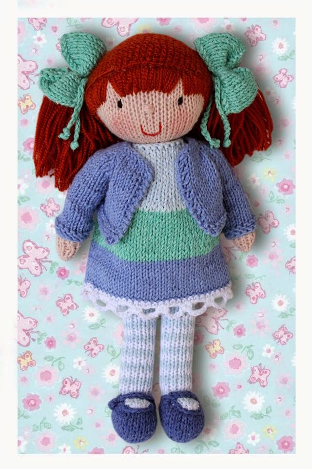 Bella - lalka wykonana na drutach. Ubrana jest w sukienkę i sweterek  wykonane ręcznie na drutach i na szydełku. Włosy lalki upięte są w kucyki.