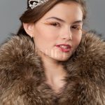 Portrait of fashion teenager model dressed in real fur and tiara with  creative make-up, posing in studio, stock photo
