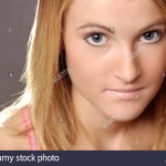 Dieses Foto zeigt eine junge Frau mit klare Haut und natürlich aussehendes  Make-up. Sie macht Blickkontakt mit dem Betrachter