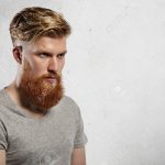 Portrait der mutigen und modernen männlichen Modell mit langen trendy Bart  und unterschnittene Frisur. Kaukasischen